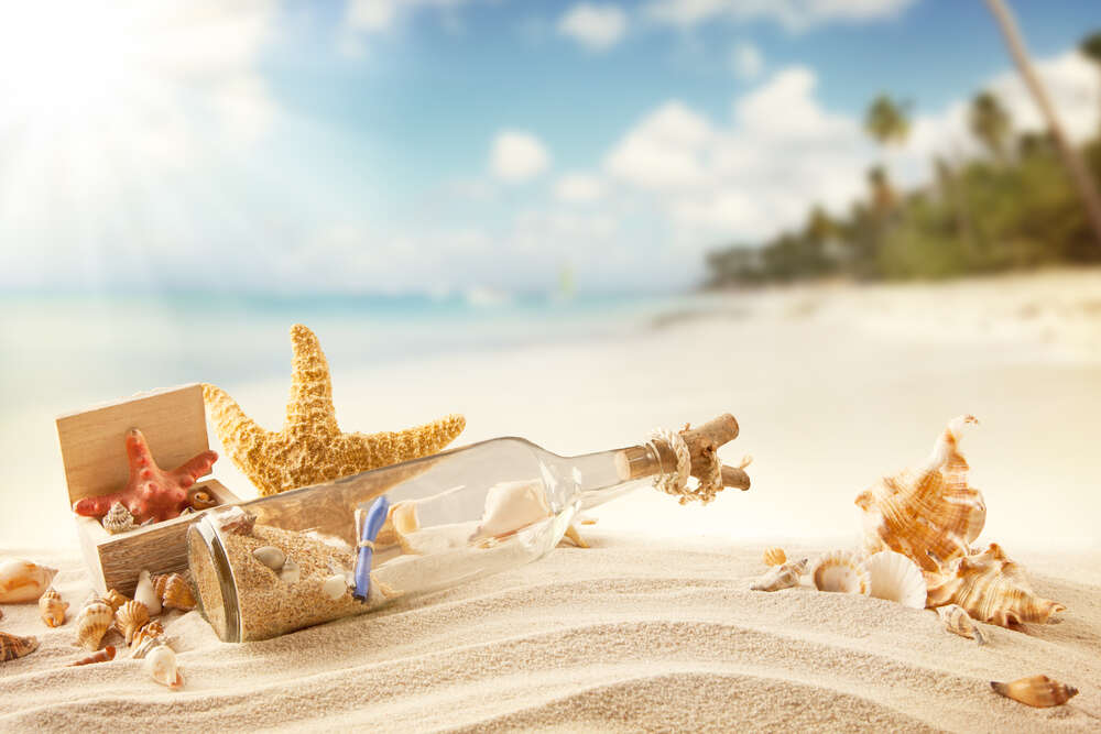 картина-постер Пляшка із загадковим повідомленням лежить на пляжі серед мушель та зірок