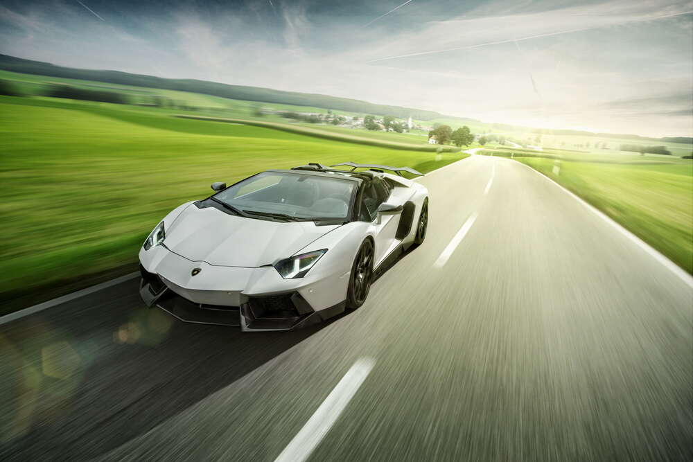 картина-постер Білий Lamborghini Aventador Roadster мчить повз зелені поля