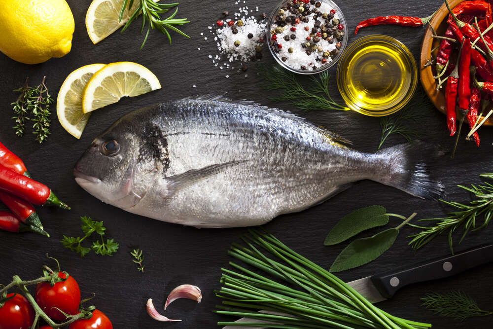 картина-постер Свіжа риба дорадо в оточенні овочів та спецій