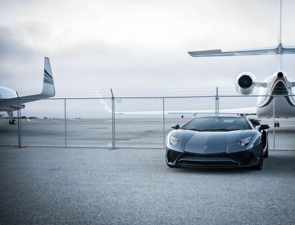 картина-постер Чёрный автомобиль Lamborghini Aventador на фоне самолетов