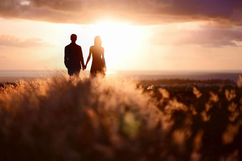 картина-постер Силуэты влюбленной пары в лучах заходящего солнца
