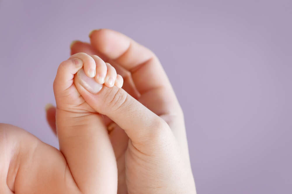картина-постер Маленькая ладошка младенца обхватила палец мамы