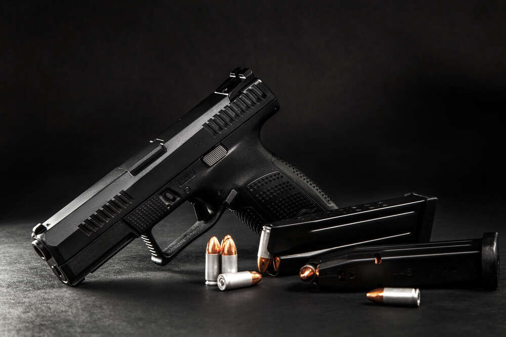 картина-постер Черный пистолет с патронами на столе