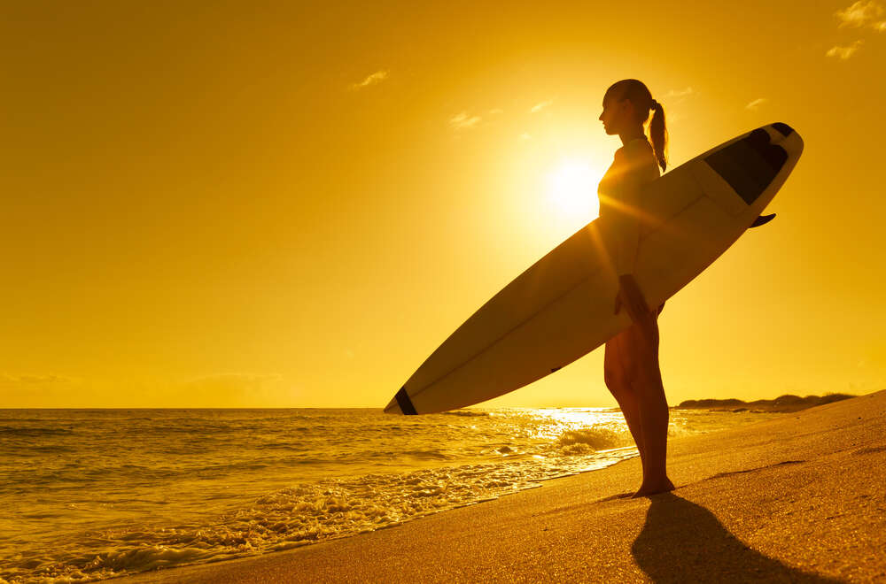 картина-постер Дівчина серфер на березі океану з дошкою