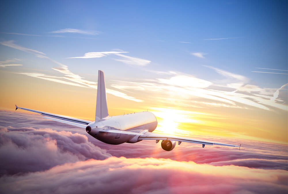 картина-постер Самолет, летящий навстречу заходящему солнцу