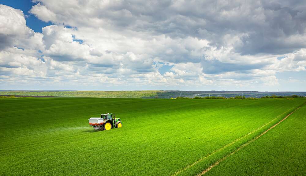 картина-постер Одинокий трактор в зеленом поле